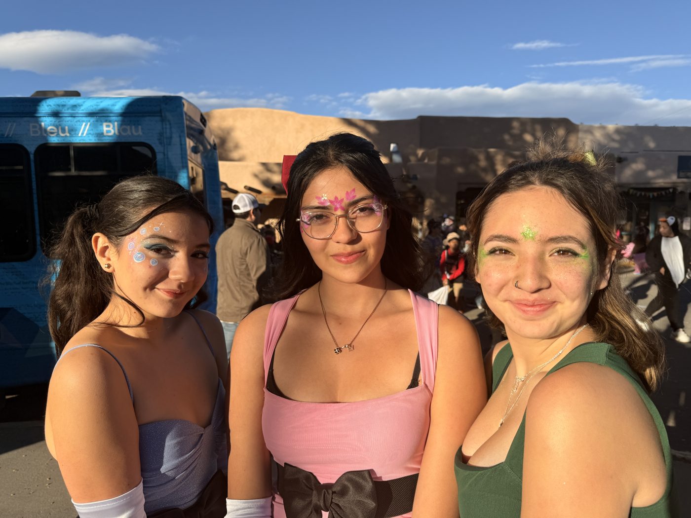 Three friends with festival face paint and glitter