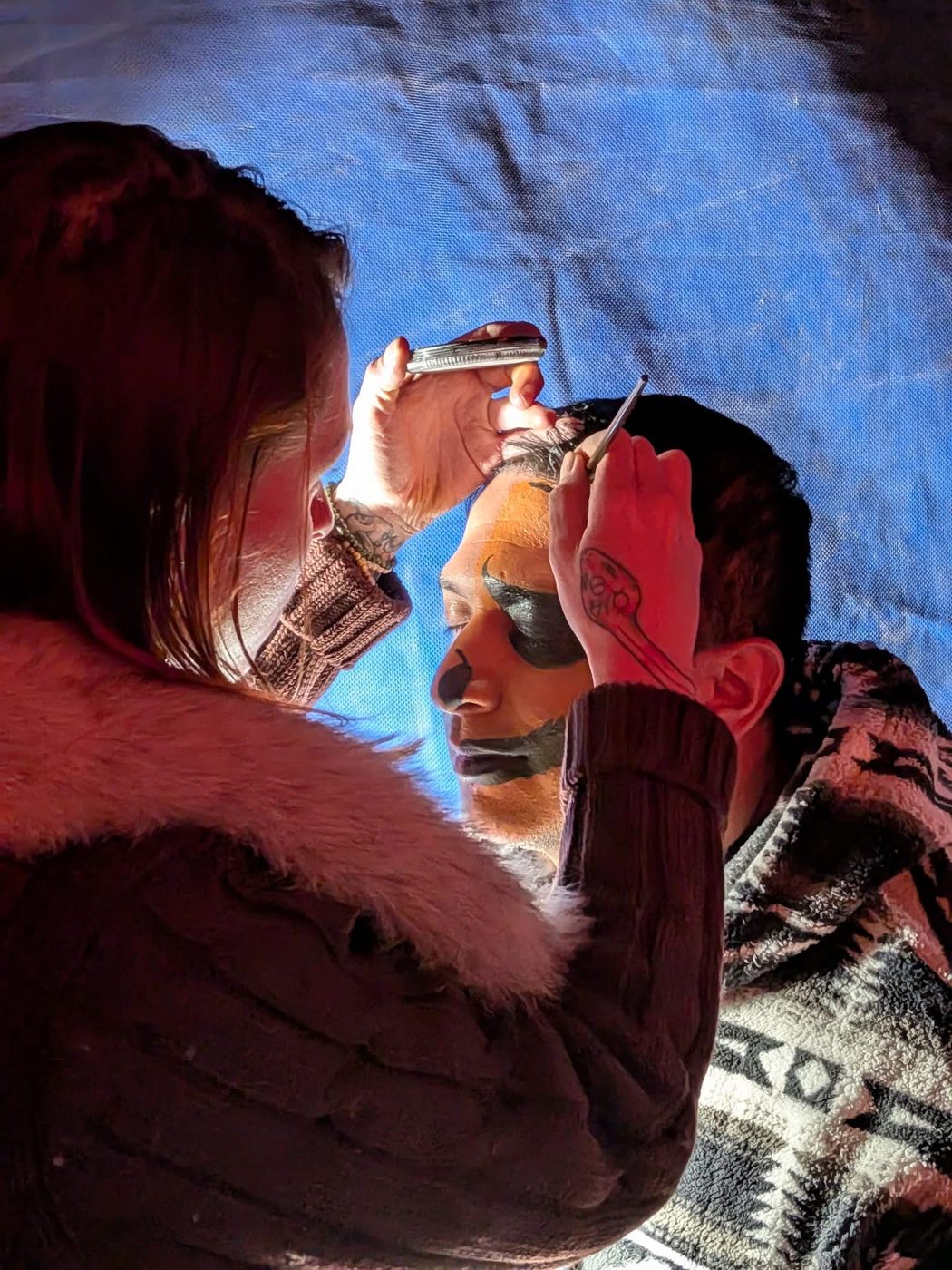 Artist at work on a dramatic face paint design